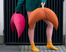 Załaduj obraz do przeglądarki galerii, kobieta trzymająca w rękach dwie poduszki księżycowe w kolorze pomarańczowym i malinowym