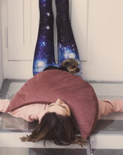 Załaduj obraz do przeglądarki galerii, kobieta leżąca na podłodze opierając nogi na drzwiach trzymając na klatce poduszkę księżycową w kolorze ciemno różowym i małego psa
