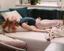 Załaduj obraz do przeglądarki galerii, kobieta medytująca na łóżku opierając plecy i głowę na piaskowej poduszce kopertowej