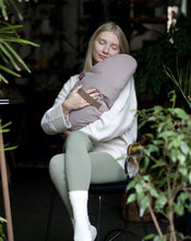 Załaduj obraz do przeglądarki galerii, kobieta siedząca na stołku przytulająca się do jasno różowej poduszki księżycowej