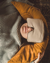 Załaduj obraz do przeglądarki galerii, kobieta relaksująca się leżąc na żółtej poduszce księżycowej z gryki trzymając na oczach lawendową poduszkę na oczy