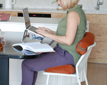 Load image into Gallery viewer, kobieta pracująca zdalnie wspomagająca swoją pracę poduszką klinową na krześle i małym wałkiem gryczanym ułożonym w odcinku lędźwiowym
