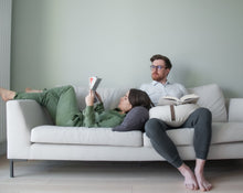 Załaduj obraz do przeglądarki galerii, para wypoczywająca na kanapie używając jako podparcie głowy i rąk poduszek księżycowych w kolorze grafitowym i piaskowym