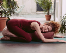 Załaduj obraz do przeglądarki galerii, Kobieta leżąca w pozycji dziecka na różowym wałku gryczanym z poduszką księżycową pod pośladkami