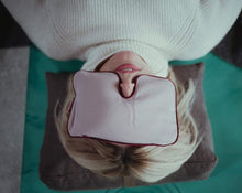 Załaduj obraz do przeglądarki galerii, kobieta relaksująca się leżąc na macie opierając głowę na brązowej poduszce klinowej z różową poduszką na oczach
