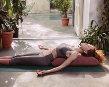 Load image into Gallery viewer, kobieta medytująca na macie leżąc na poduszce kopertowej w kolorze ciemny róż

