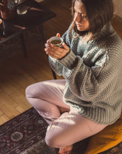 Load image into Gallery viewer, kobieta siedząca na żółtej poduszce do medytacji w kształcie księżyca pijąca herbatę
