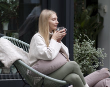 Załaduj obraz do przeglądarki galerii, kobieta siedząca na fotelu z wikliny pijąc herbatę i trzymając poduszkę księżycową na nogach
