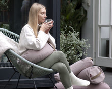 Załaduj obraz do przeglądarki galerii, kobieta pijąca herbatę na fotelu wiklinowym trzymając jasno różową poduszkę obciążeniową z gryki na nogach
