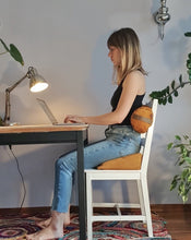 Załaduj obraz do przeglądarki galerii, kobieta przed komputerem wspierająca swoje plecy żółtą poduszką klinową z gryki na krześle i żółtym wałkiem gryczanym ułożonym w odcinku lędźwiowym
