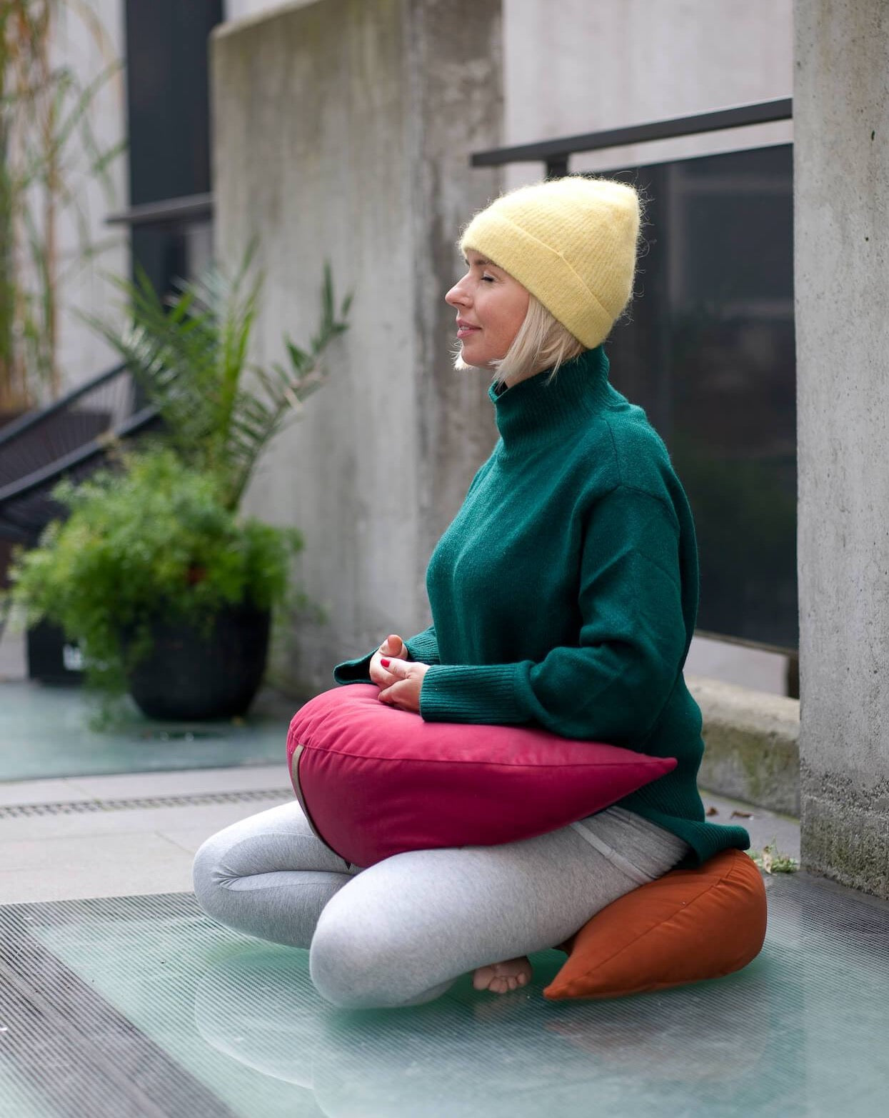 kobieta medytująca używając poduszek księżycowych jako siedzisko i poduszka obciążeniowa na nogi