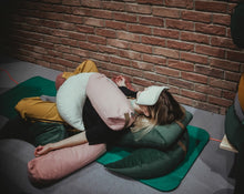 Load image into Gallery viewer, kobieta relaksująca się na macie na poduszkach gryczanych które wspierają i obciążają jej ciało
