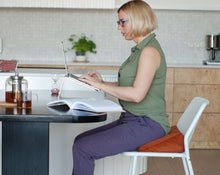 Załaduj obraz do przeglądarki galerii, Kobieta pracująca zdalnie używając poduszki klinowej na krzesło jako wsparcie pleców
