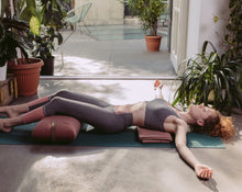 Load image into Gallery viewer, kobieta relaksująca się na macie z poduszką kopertową w kolorze różowym pod kolanami
