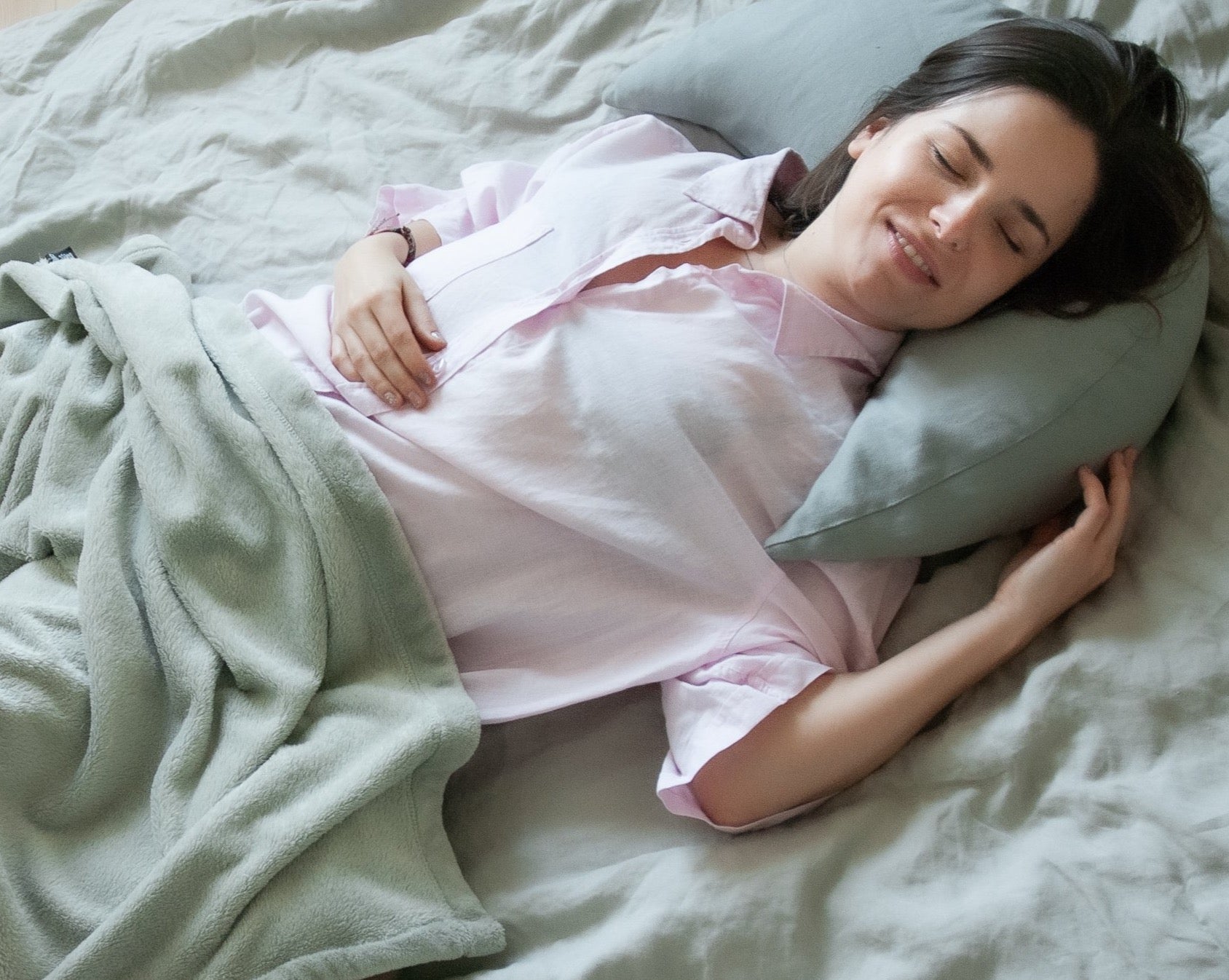 kobieta relaksująca się w łóżku wypoczywając na poduszce księżycowej koloru szarego